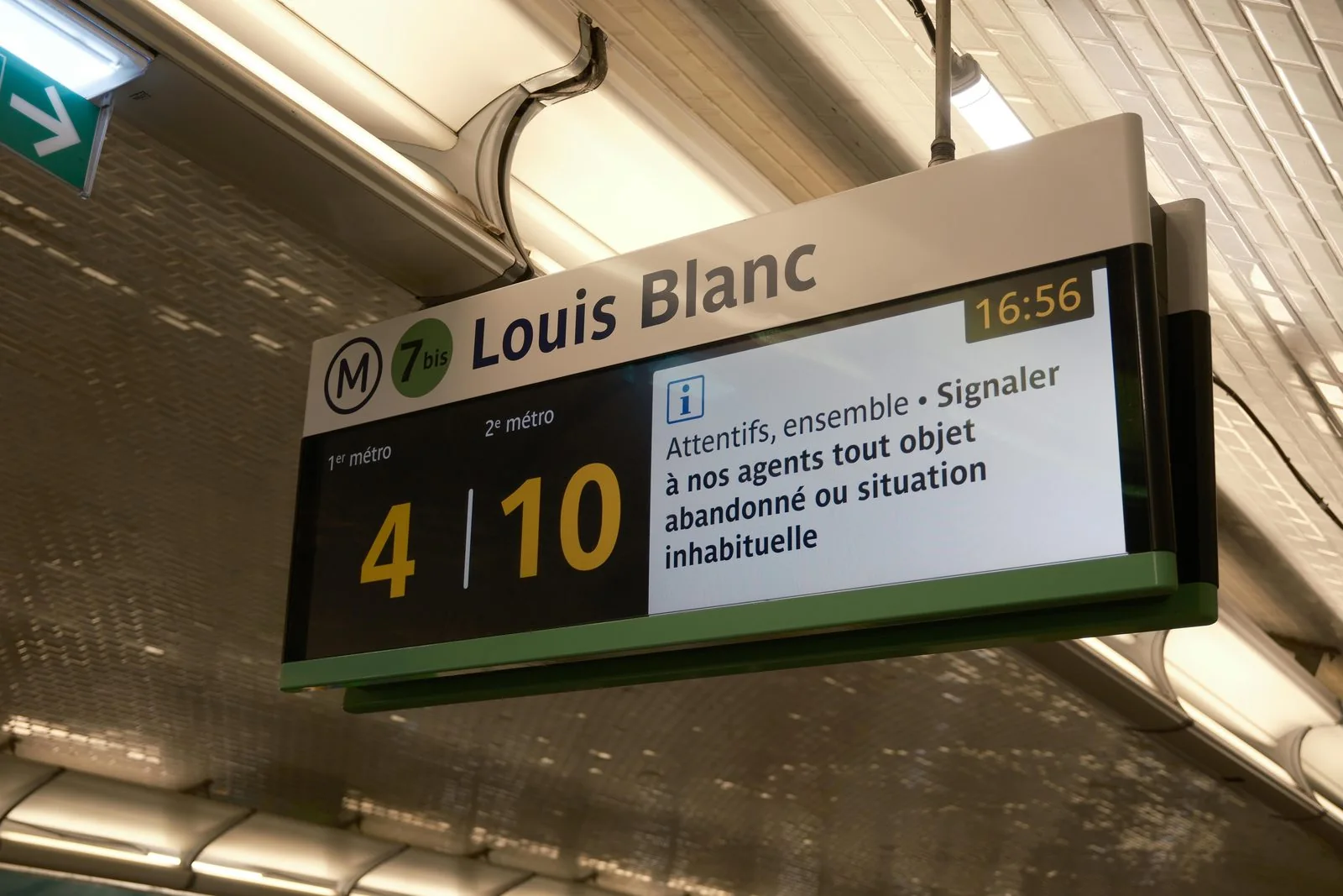 Ultra-wide bar type LCD display showing live train information on a metro platform
