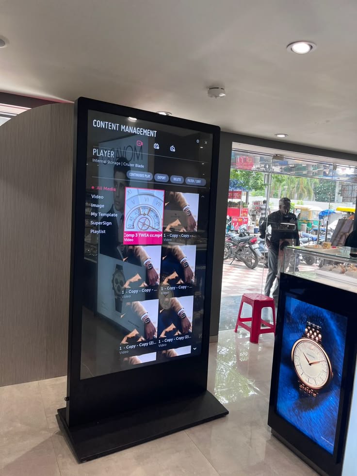 Portrait digital signage display showing a content management interface in a retail setting