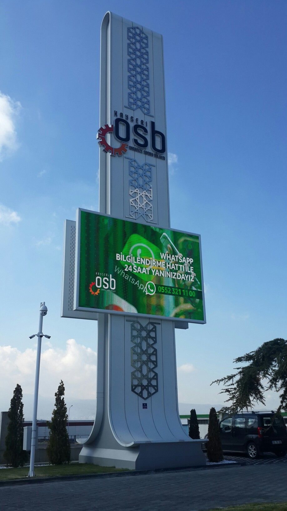 Tall outdoor LED totem display operating in direct sunlight at an industrial park