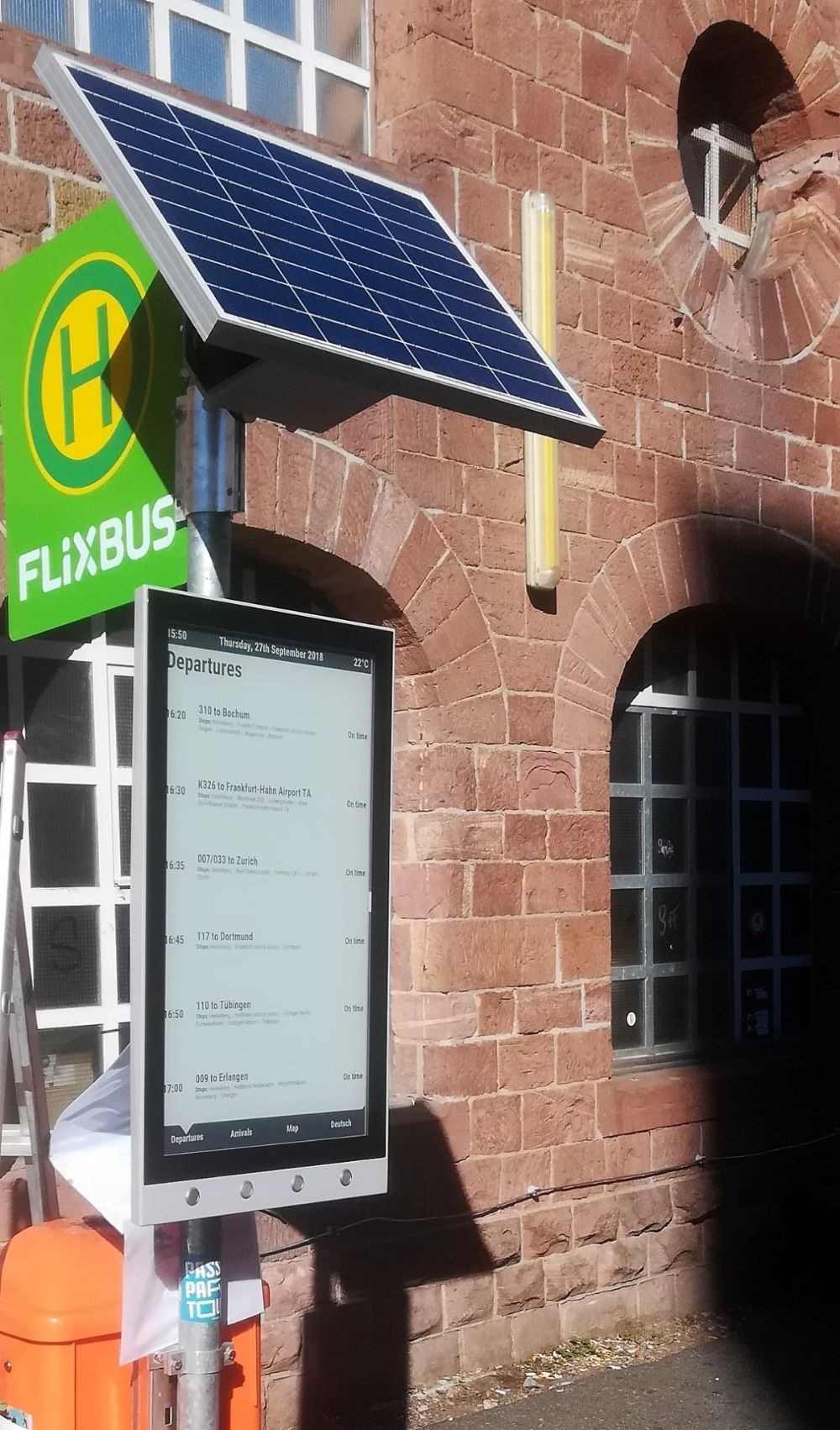 Solar-powered outdoor transit information display at a bus stop