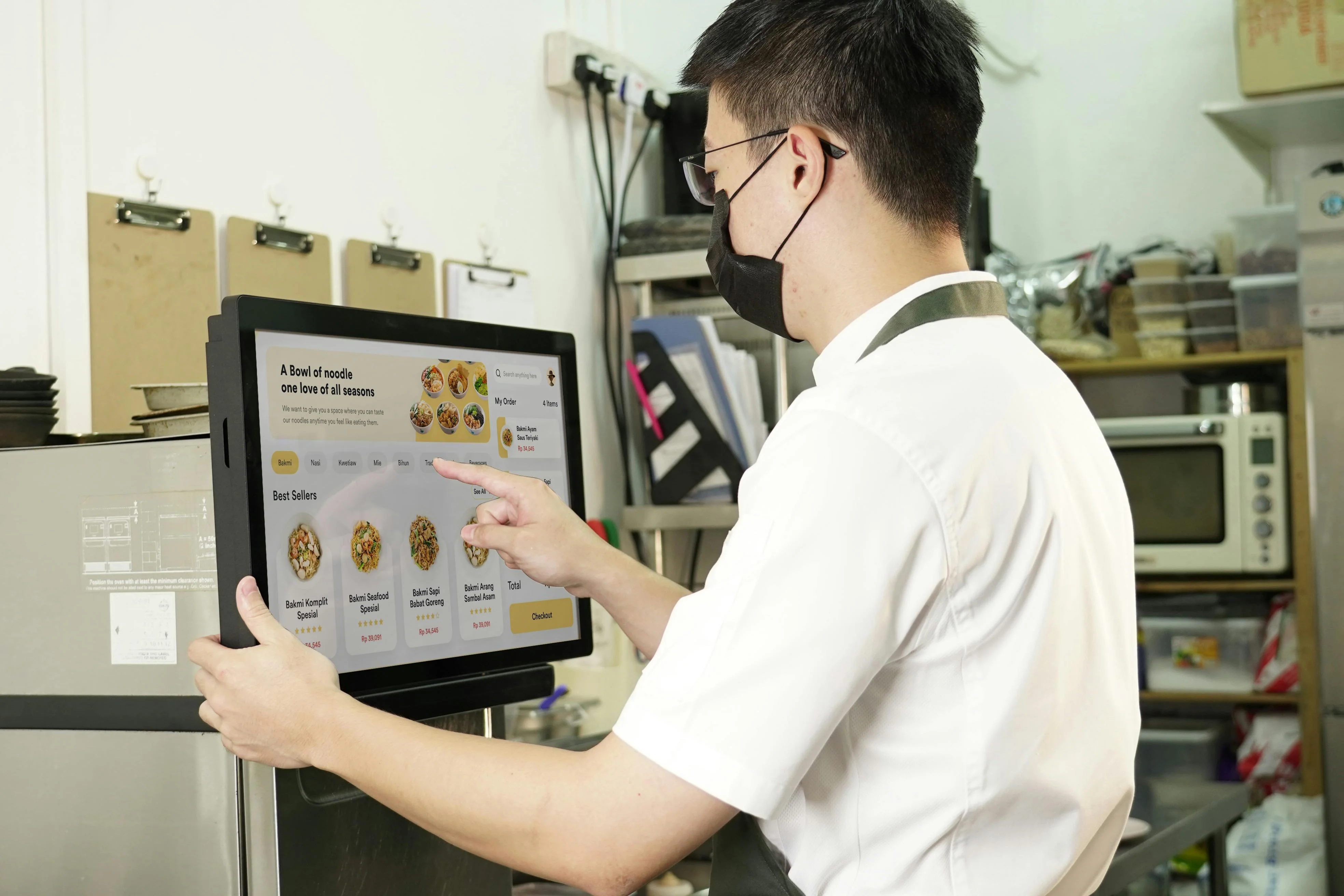 Staff using a POS touchscreen at a retail counter