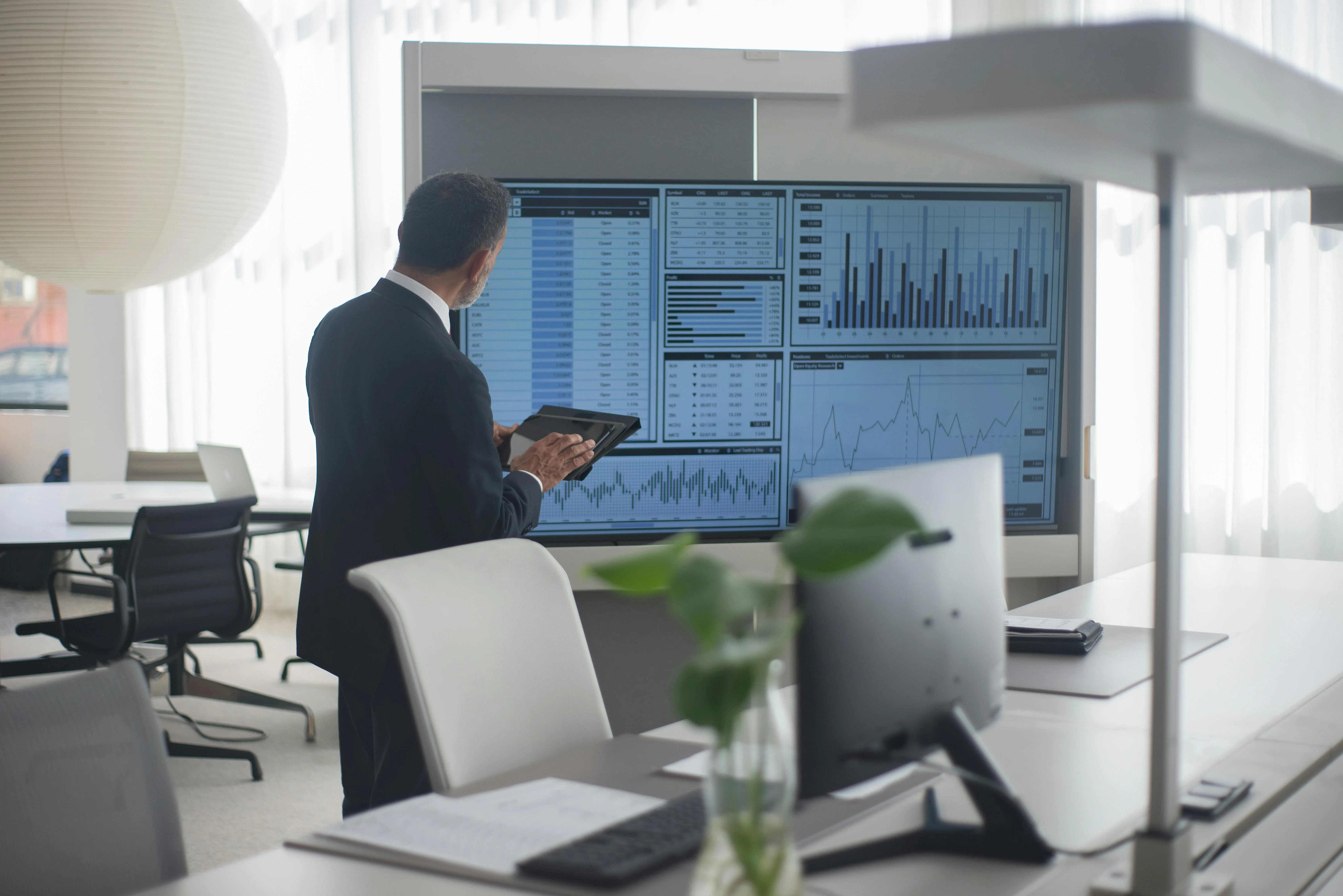 Analysts at workstations with multiple displays for financial monitoring