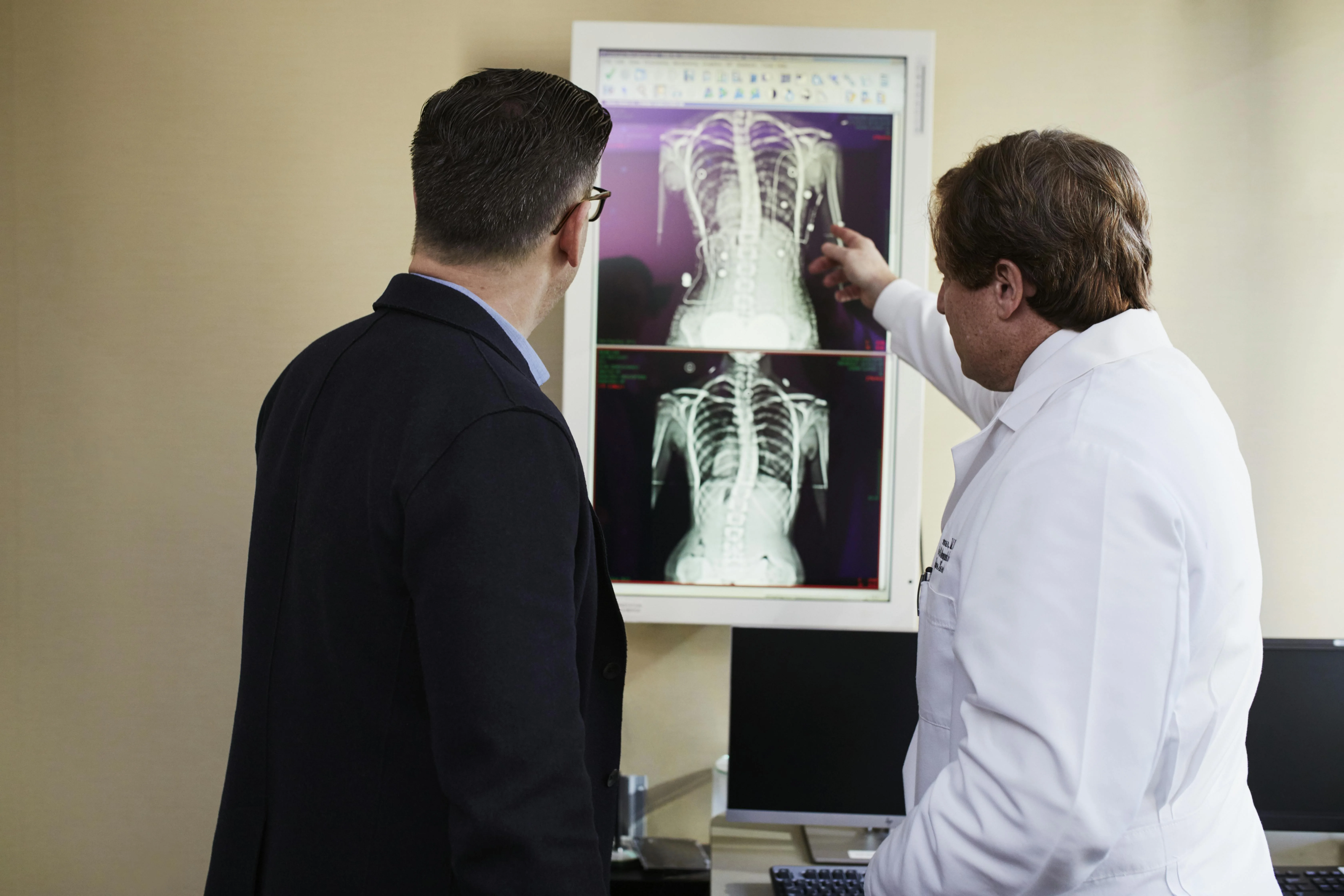 Healthcare professionals collaborating near medical imaging and monitoring displays