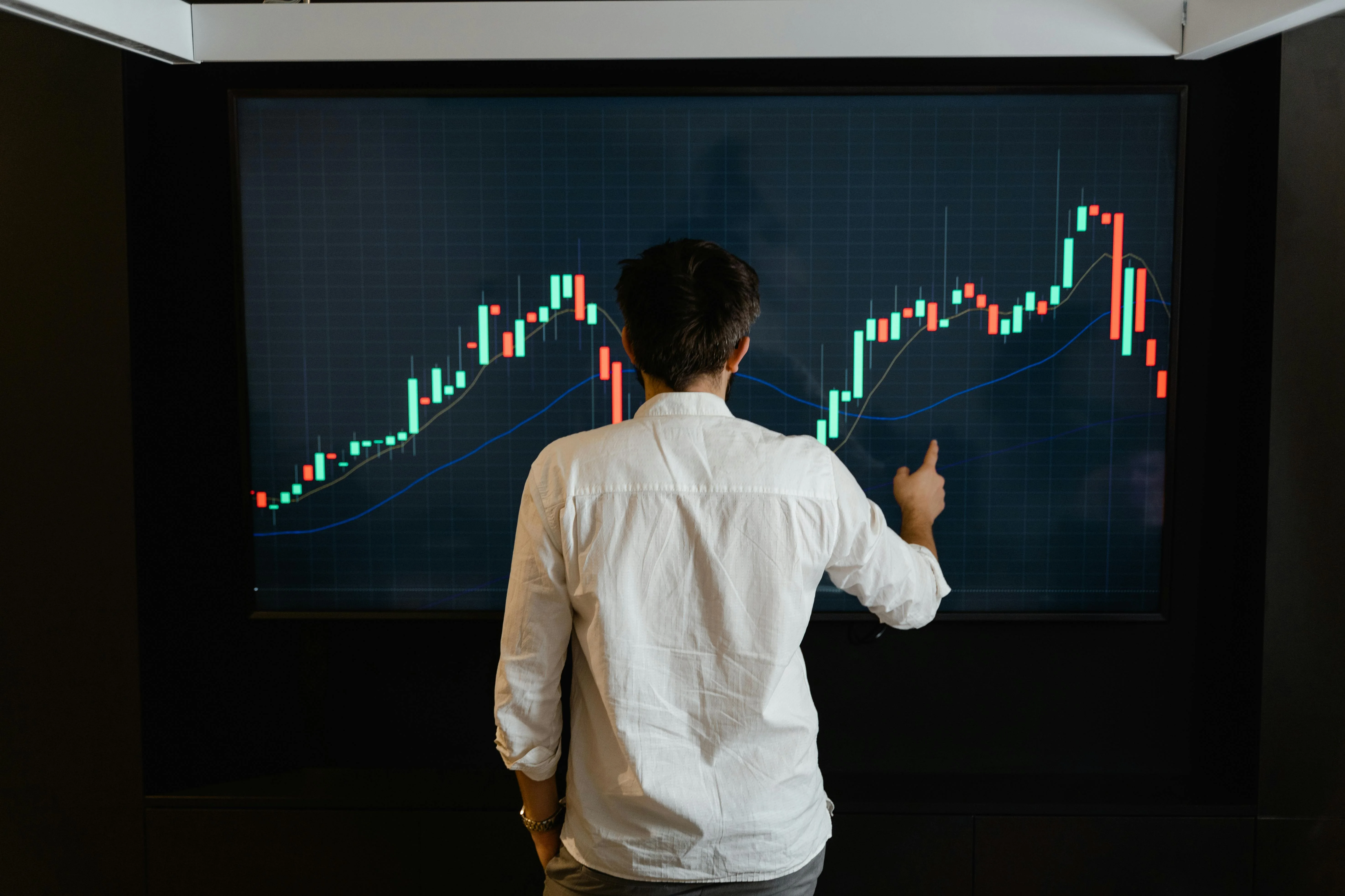 Professional reviewing financial data on screen in a modern office setting